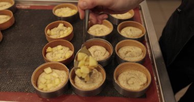 Pasta masasında elmayla doldurulurken pastalar..