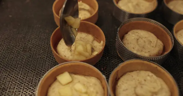 Pasta masasında elmayla doldurulurken pastalar..