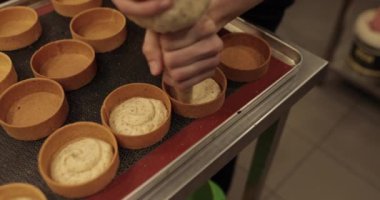 İçinde krema olan büyük bir plastik şırınga turtaları doldurur. Pasta şırıngasından akan kremanın yakın çekimi ve tartı doldurmak..
