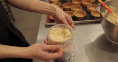 Kadın elleri kremi sıkmak için mutfak şırıngasına döker..