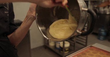 Kadın elleri kremi sıkmak için mutfak şırıngasına döker..