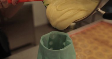 Kadın elleri kremi sıkmak için mutfak şırıngasına döker..