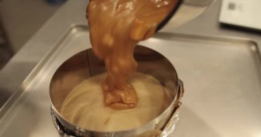 Bir pasta şefi tatlı karışımını bir kaseye koyar. Pasta yapma süreci yakın plan.