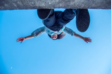 Genç adam trambolinde havada zıplıyor.