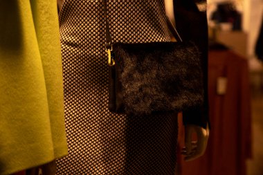 Siyah elbiseli manken ve çantalı bir çanta.