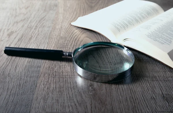 Ahşap zemin üzerinde büyüteç olan cam.