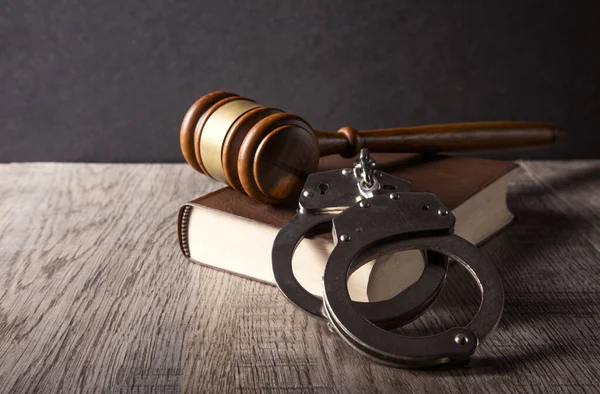 Hukuk kavramı - kelepçe, tokmak ve ahşap masa üzerindeki kitaplar