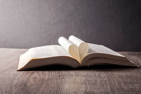 Eski kitaplar ve ahşap masada açık sayfalar. Metin için boşluk
