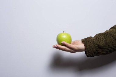 Yeşil elma kadının elinde. Yaklaş.