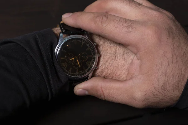 man pointing at hand watch