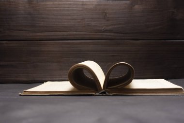 Koyu siyah ahşap zemin üzerine açılan kitap