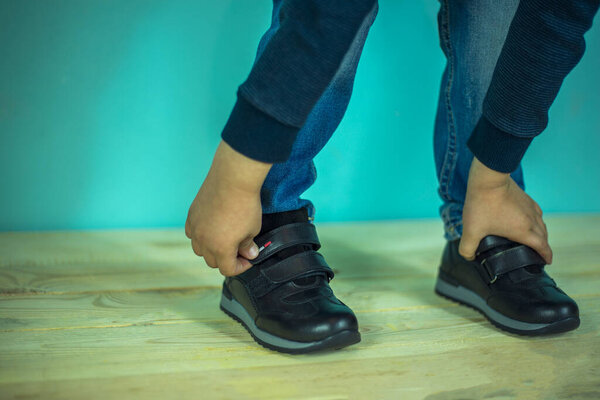 Тайский мальчик завязывает шнурки