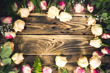 Çiçek kompozisyonu. Ahşap arka planda gül çiçeklerinden yapılmış çerçeve