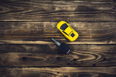  Tahta arka planda küçük sarı bir araba.