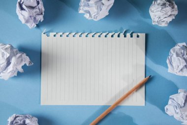 Buruşmuş kağıt toplar ve defter kalemi