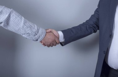 İş arkadaşları alkışlarken ve alkışlarken iş adamları toplantıda el sıkışıyor..