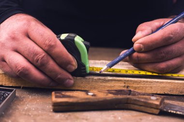 Cetvelli marangoz ahşap kalas ölçüyor..