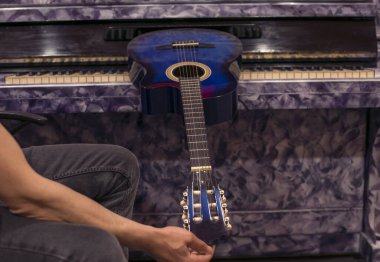 Erkek eli akustik gitarı ayarlıyor