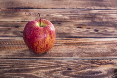 Ahşap arka planda bir kırmızı elma