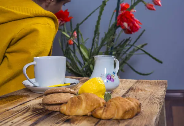 Breakfast - tea with lemon, croissant,   on a white table background