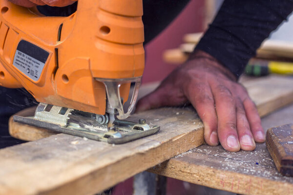 Человек пилит фанеру мозаикой.. 
