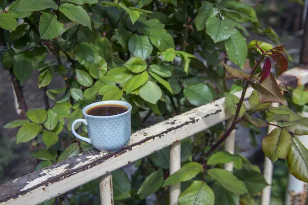 ceramic cup with coffee in a garden
