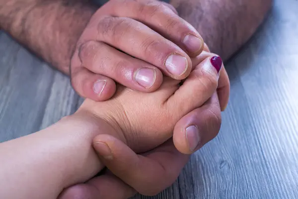 Close up on a man and a woman holding hands