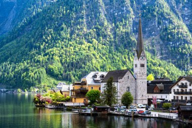 Avusturya 'daki Hallstatt Kilisesi' nin arka planında dağları olan manzarası.