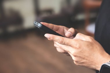 Cep telefonunu elinde tutan adamın görüntüsünü kapat