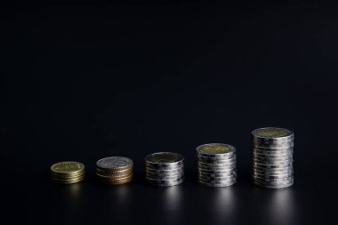 Siyah arkaplanı olan bozuk para yığını.