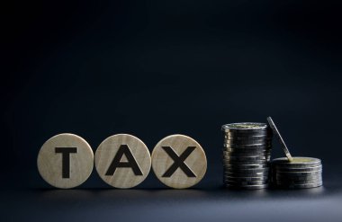 Siyah arka planda tahta küpler ve madeni paralar. vergi kavramı, vergiler ve vergi.