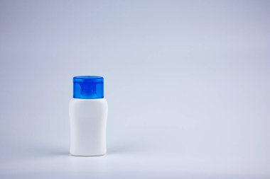 Mavi arka planlı beyaz plastik şişe