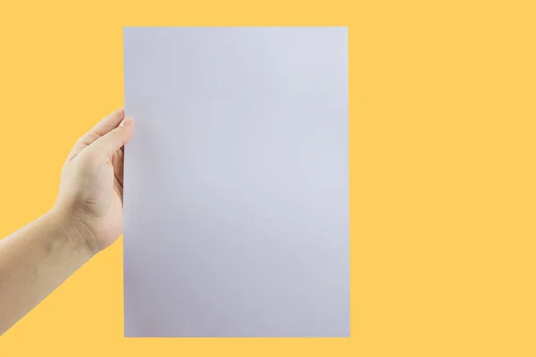 Χέρι Κρατώντας Ένα Λευκό Χαρτί Κίτρινο Φόντο — Φωτογραφία Αρχείου
