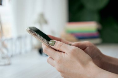 El, sosyal medyayı takip etmek ve çevrimiçi bilgi aramak için akıllı telefon uygulaması kullanıyor.