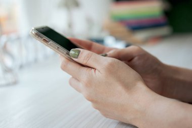 El, sosyal medyayı takip etmek ve çevrimiçi bilgi aramak için akıllı telefon uygulaması kullanıyor.