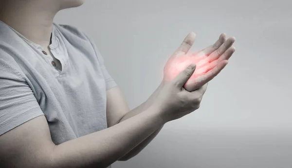 woman holding a wrist pain on gray background