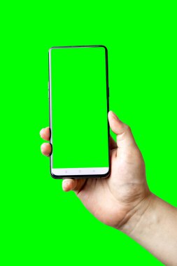 Beyaz ekran yeşil arka planda izole edilmiş akıllı telefonu tutan bir erkek. Reklam ve halkla ilişkiler için kopyalama ve tasarlama alanı ile.