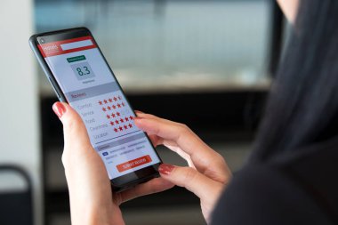 Otel hizmetlerinden müşteri memnuniyetini değerlendirmek. Akıllı telefon kullanan kadın müşteri çok iyi bir tatmin notu verdi ve otelin internet uygulaması tarafından sağlanan hizmetler hakkında tavsiye verdi