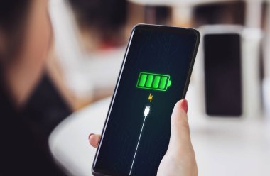 Cep telefonu ekranı, akıllı telefonu şarj cihazıyla ya da güç bankasıyla fişe takarak tam akü şarj başarısını bildirir. Enerji teknolojisi kavramı, modern güç sisteminin kolaylığı