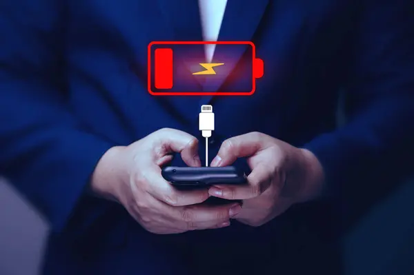 Smartphone\'s battery power is running low with a virtual low battery symbol warning on the screen. Concept of reserve energy and technology