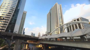 Sathorn kavşağındaki başkentte yoğun gökdelenlerden oluşan bir gökdelenle motosiklet ve araba trafiğinde 4K zaman aşımı. Chong Nonsi Köprüsü