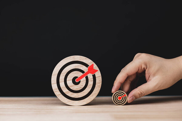 Решительность и успех. Два деревянных круга с иконками мишеней разных размеров. концепции методов и планирования для постановки целей, начиная от малых целей до больших целей.
