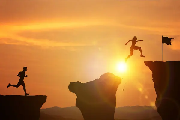 Çabalamak ve başarıya bağlılık. Kadın ve erkek silueti, parlak güneşli bir dağda bitiş çizgisine ulaşmak için uçurumdan atlamak için yarışıyor. Zaferler ve eğitim için hedefler belirleme kavramı