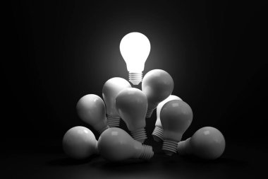 Parlak ampul, karanlıkta beyaz bir ampulün üzerinde yüzer. Yetenekli liderlik kavramı ve olağanüstü fikirler, iyi fikirler, yenilikler ve ilham