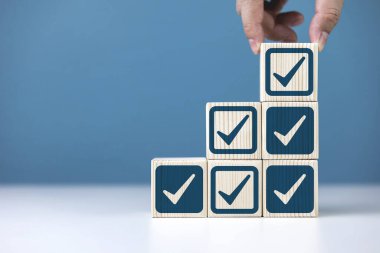 Standartların denetlenmesi ve onaylanması. Tahta blokta işaret var. Öge doğrulama, istihdam listesi ve ürün kalitesi sertifikası kavramı.