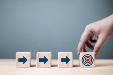 İş adamının elinde hedef ikonu gösteren bir okun olduğu kırmızı bir dart tahtası sembolü var. İş tanımlama görevi, hedefler ve başarı süreçleri kavramı.