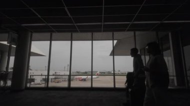 Bangkok, Tayland. Don Mueang Havaalanı, Bangkok 'taki uçağa binmek için bekleyen yolcular. Biniş kapısının içinde bir servis dükkanı var..