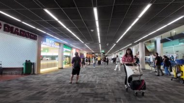 Bangkok, Tayland. Don Mueang Havaalanı, Bangkok 'taki uçağa binmek için bekleyen yolcular. Biniş kapısının içinde bir servis dükkanı var..