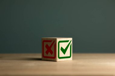 Tahta küpte yeşil işaret ve kırmızı haç simgesi. Doğru ve yanlış. Kontrol listeleri, onay listeleri ve test kavramları.