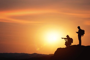 Planlama ve yön belirleme fikirleri. İki iş adamının siluetleri ile iş konsepti gün batımı geçmişiyle dağa seyahat etmeyi planlıyorlar..